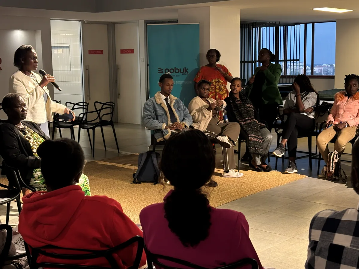 A speaker in conversation with participants seated around the discussion circle